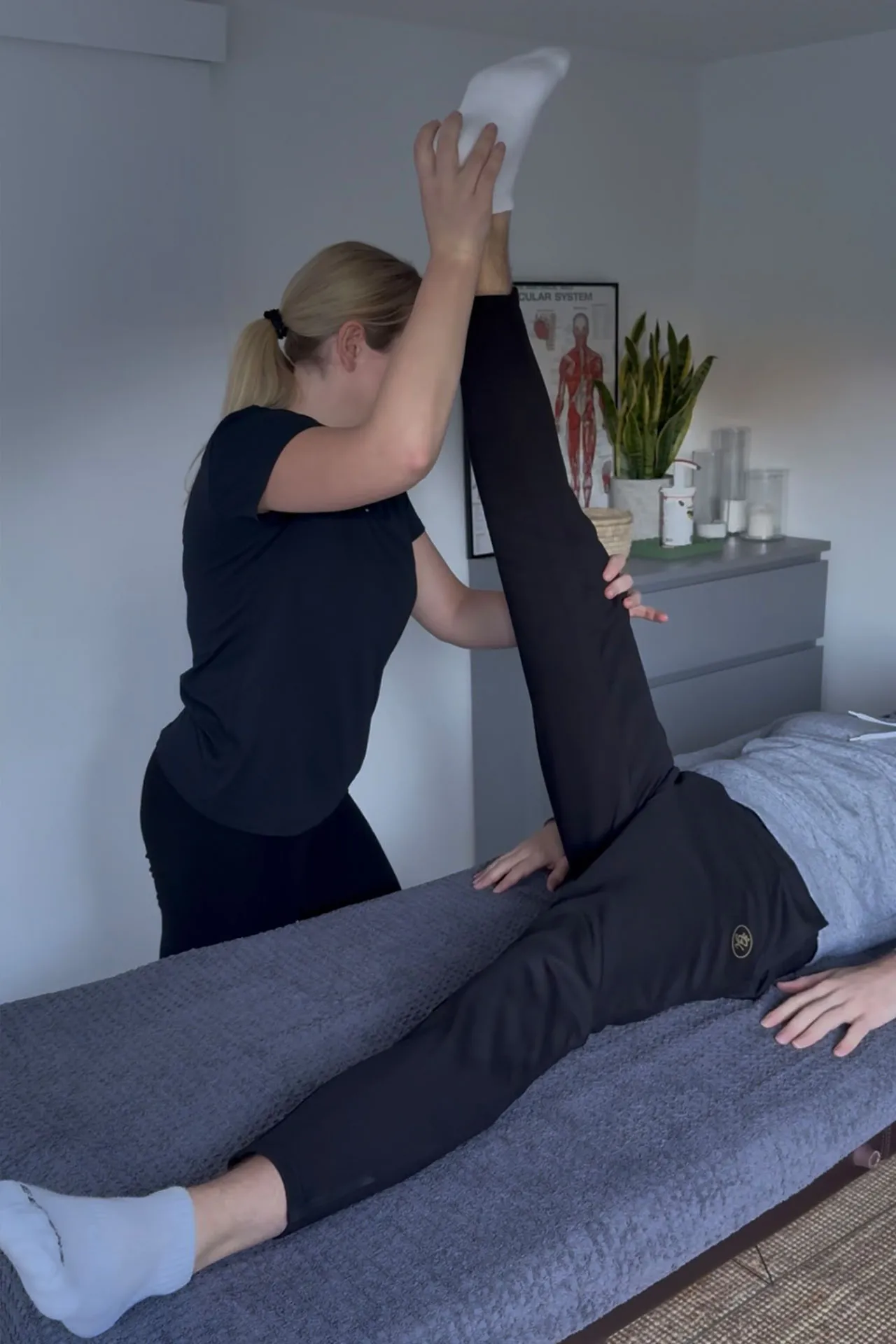 Assisted Stretching session - therapist helping a client stretch on a treatment table.